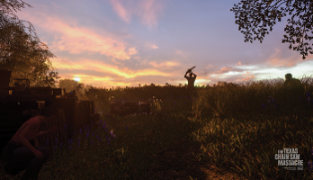 LeatherFace stands in the middle of a field at sunset with his chainsaw raised in the air.